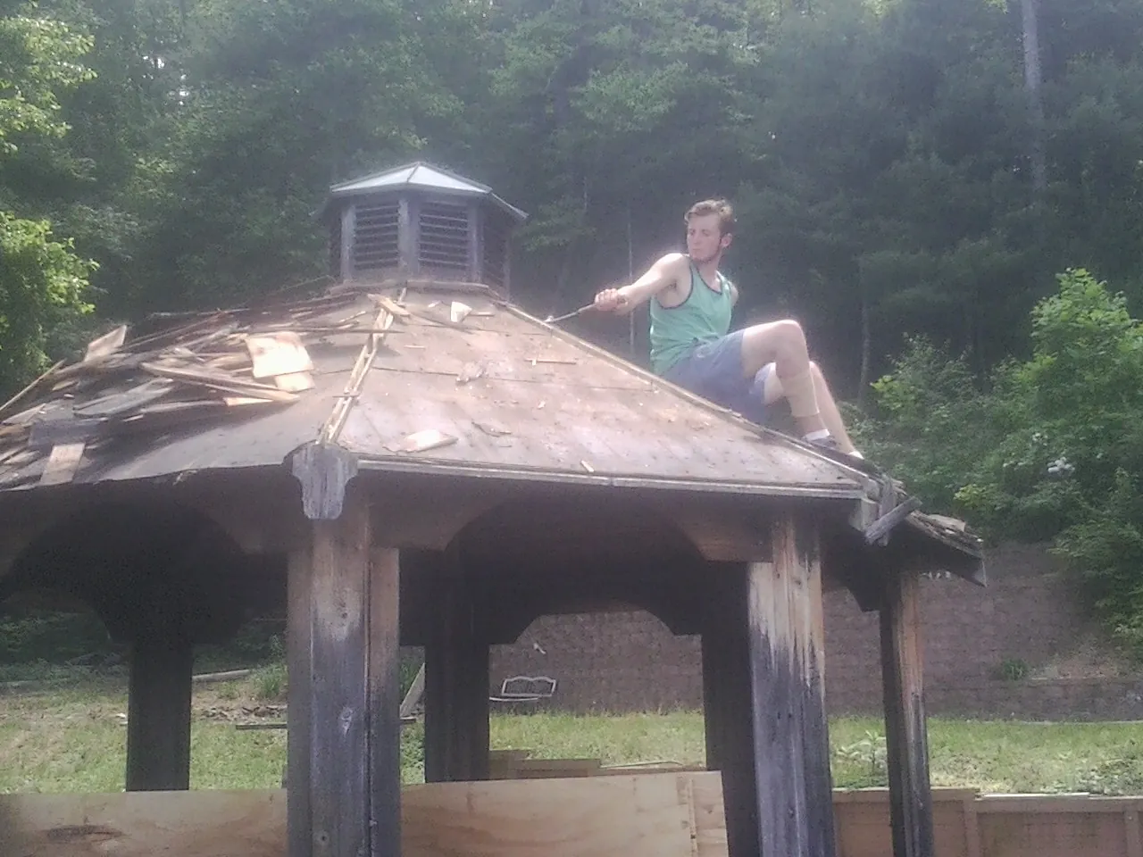 Tearing the old roof off a wooden gazebo before new shakes in La Harpe