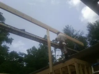 Carpenter setting a ridge beam over a new addition frame — Ice Dam Removal by Roofing Brothers in La Harpe