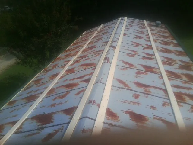 Rusted metal roof panels with new wood purlins before replacement — Storm Damage Roof Repair in La Harpe by Roofing Brothers