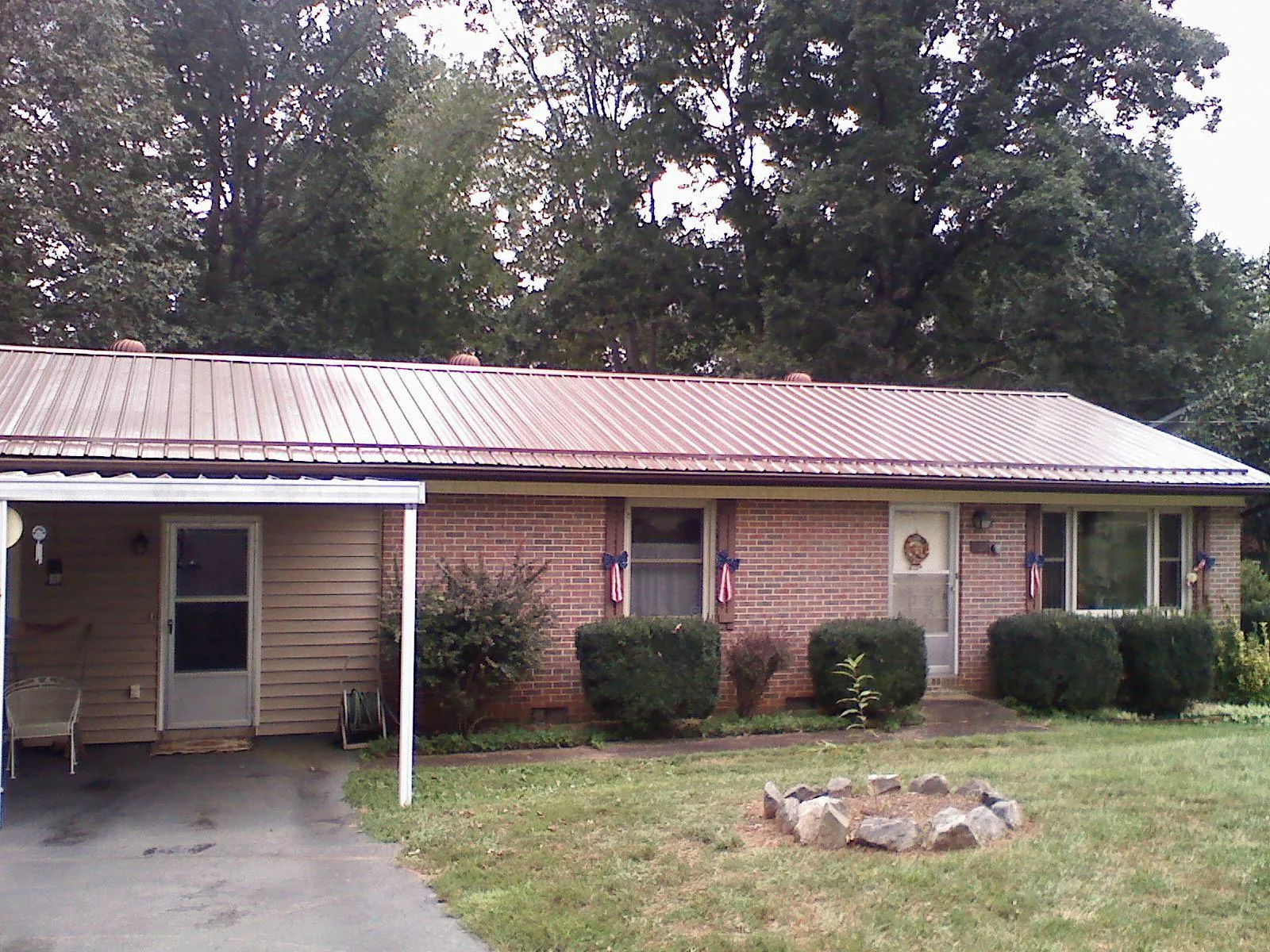 Bronze metal roof and carport on a brick ranch home — Roof Repair work by our crew in La Harpe